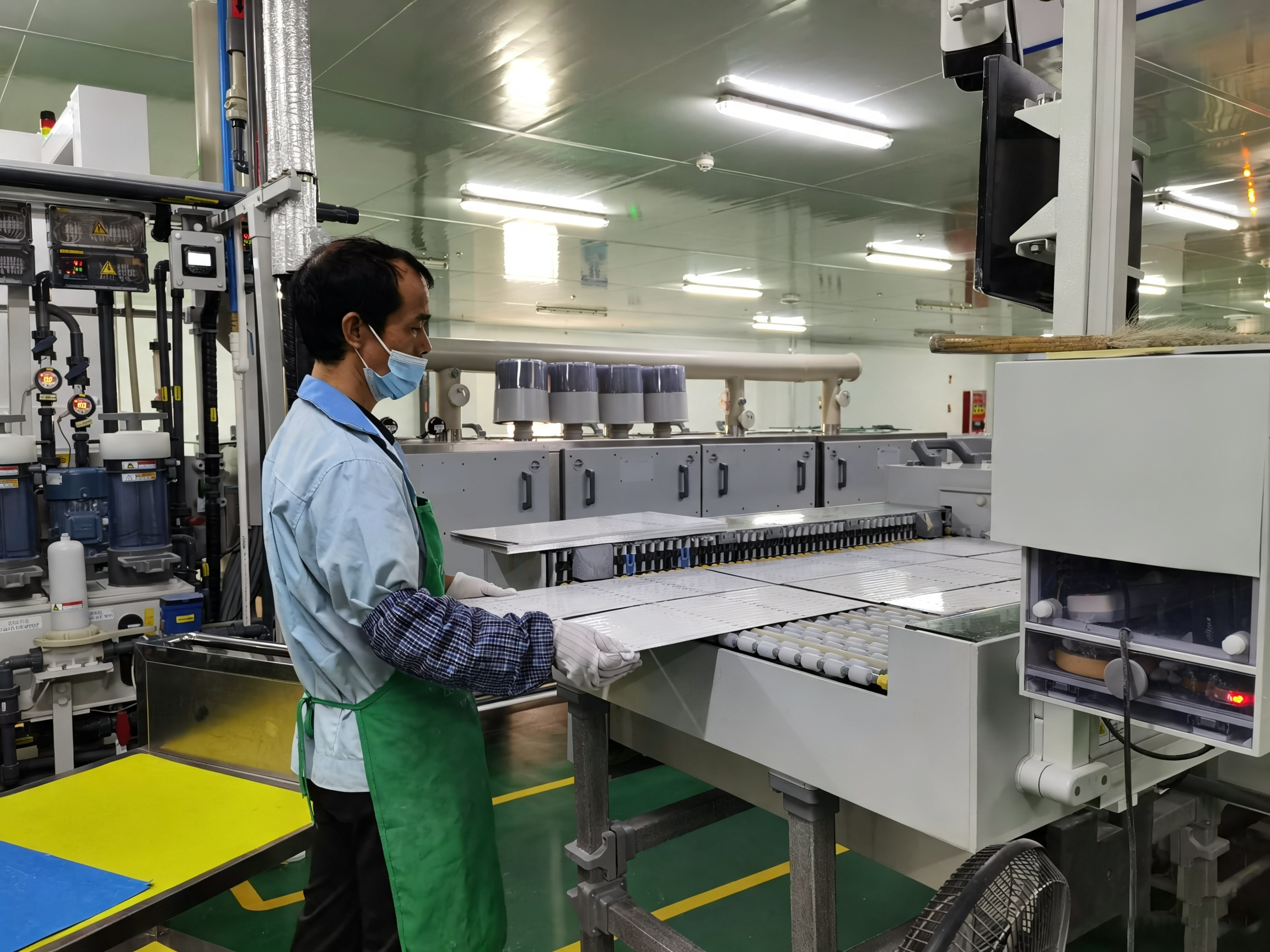PCB manufacturing production line with operator handling circuit board panels